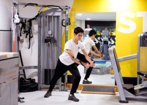 Student in the gym using a weights machine