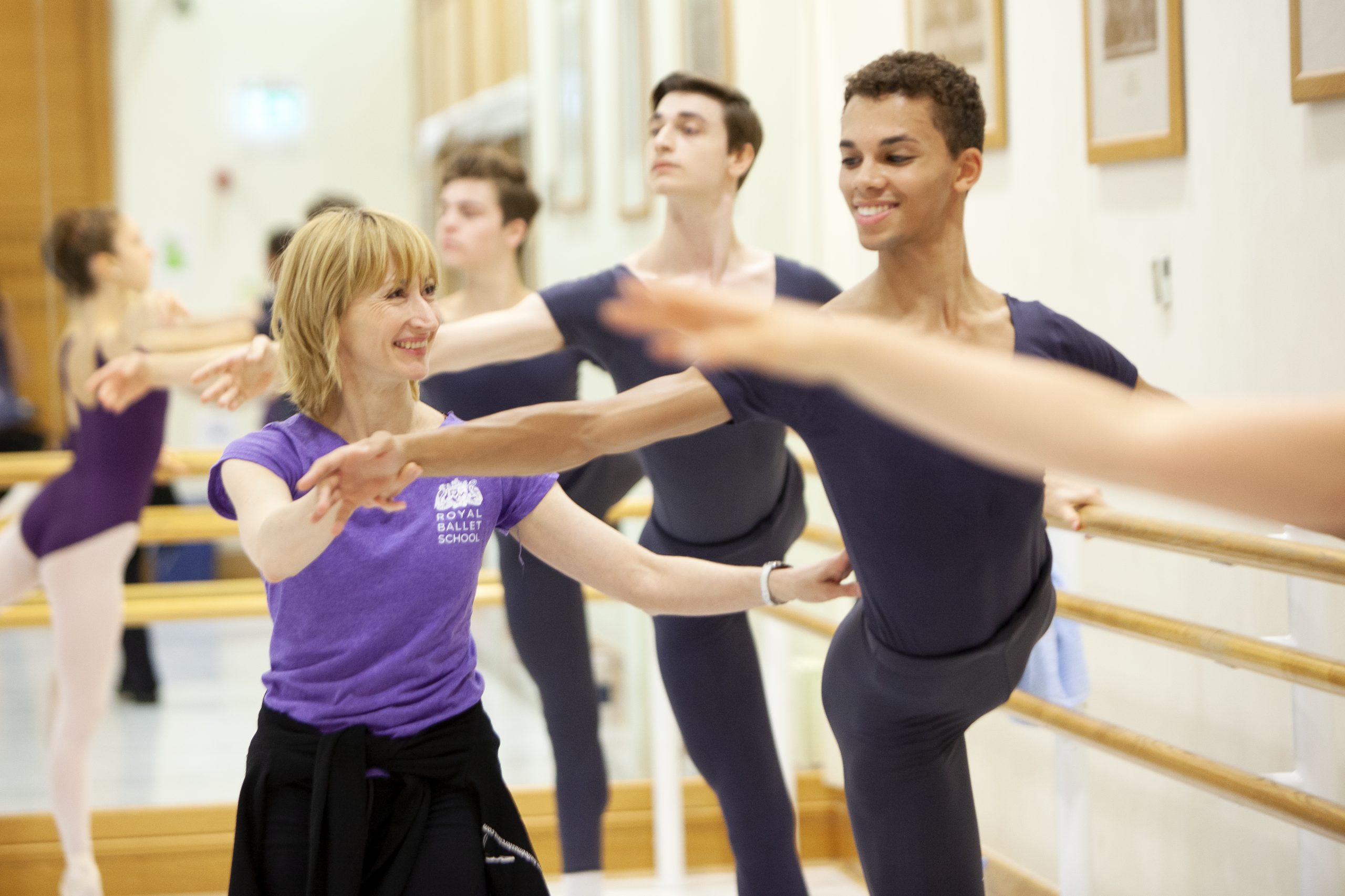 Ballet teacher helping a student at the barre